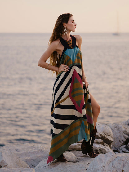 Woman in a colorful dress standing on rocks by the water